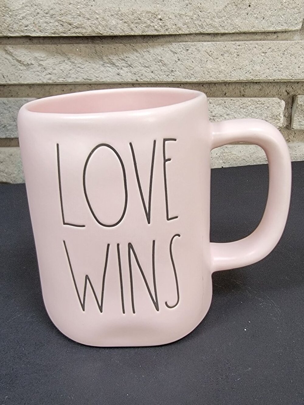 Rae Dunn ceramic mug by Magenta, "Love Wins" in black lettering on pink glaze